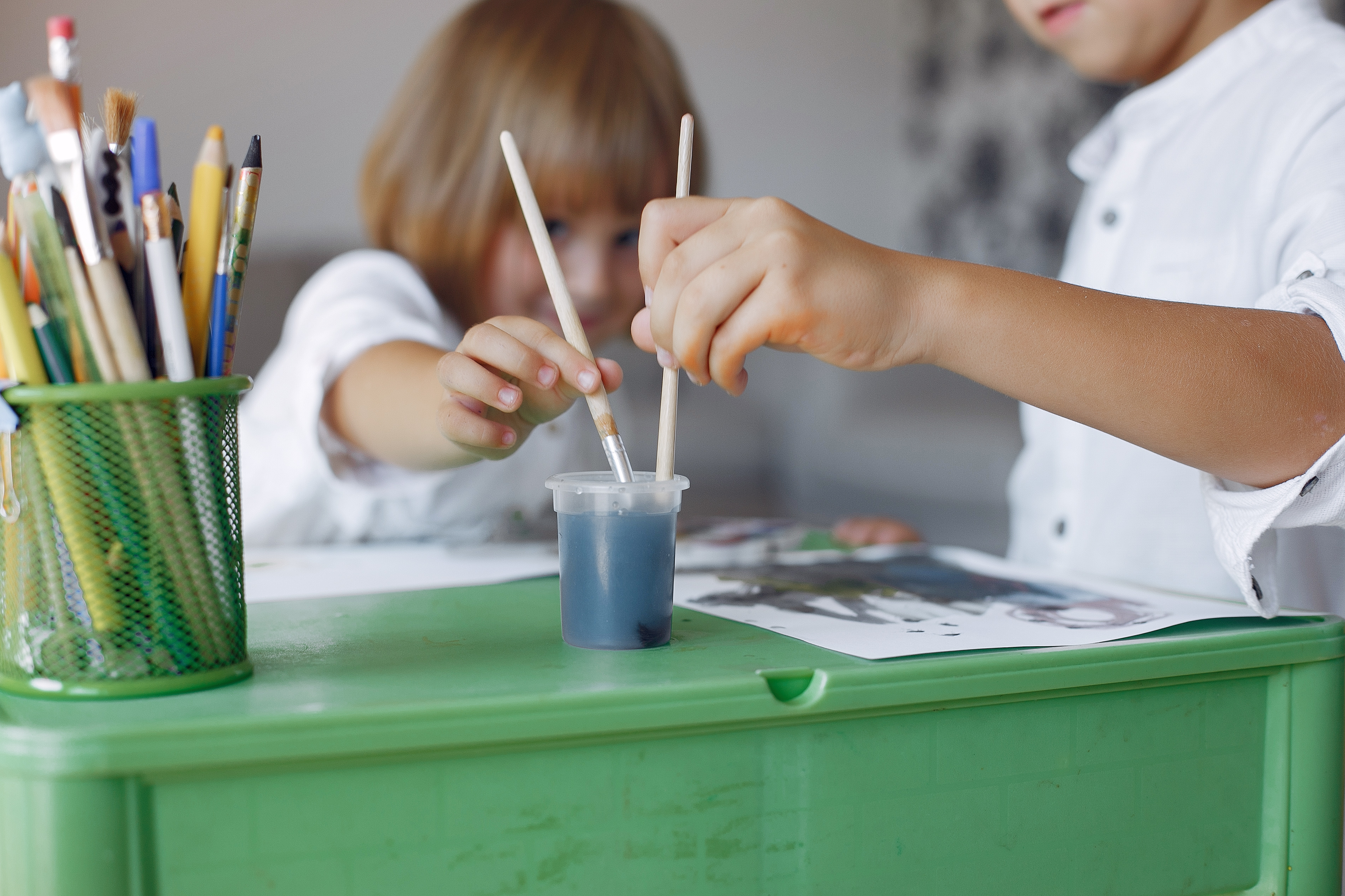 Занятия в маленьком городе. Рисуем с детьми. Дети рисуют картинки. Дети рисуют за столом. Стол художника.