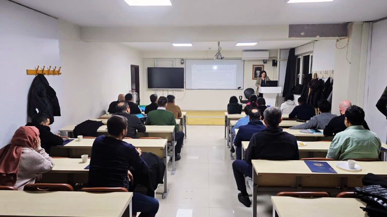 Sınıf ortamında eğitim alan katılımcılar, eğitmenin sunumunu dikkatle dinliyor.