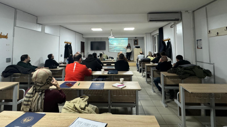 Eğitim ortamında sunum yapan eğitmen ve katılımcılar